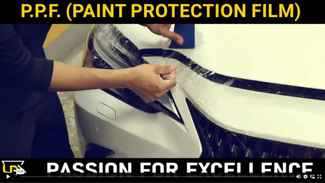 a person putting a protective film on a car